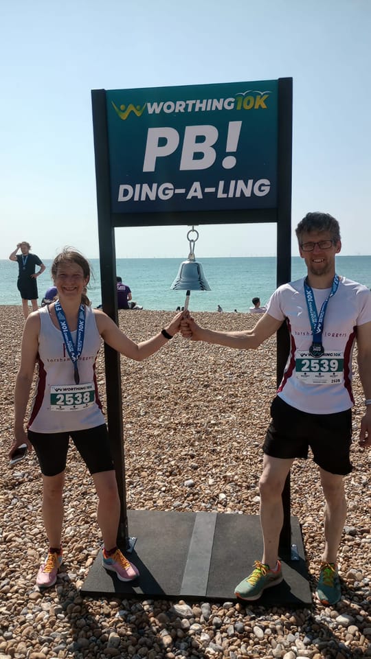 Jo and Brian Stone about to ring bell on a beach