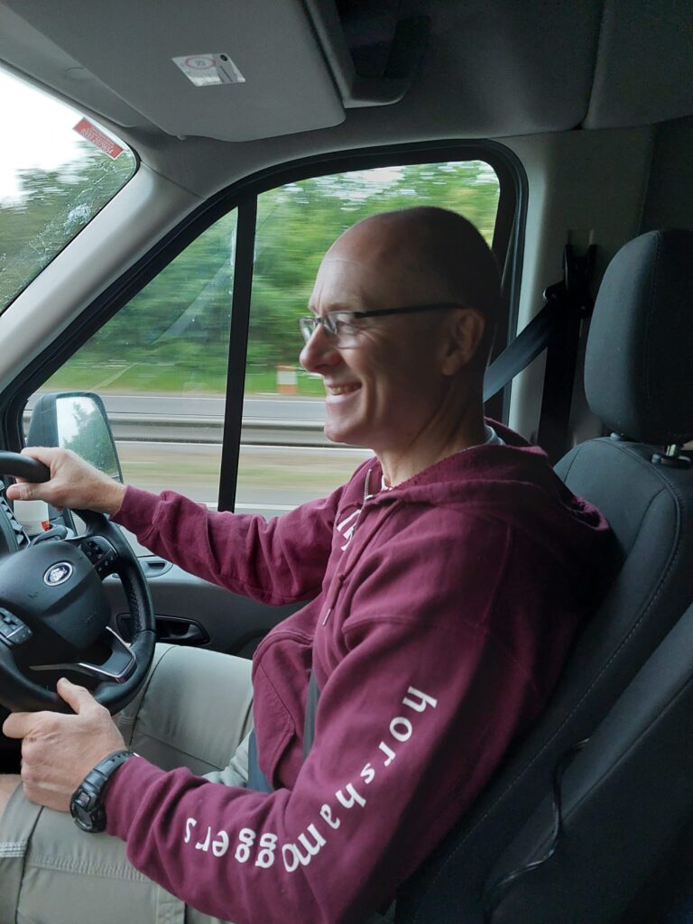 John Willcox driving a minibus