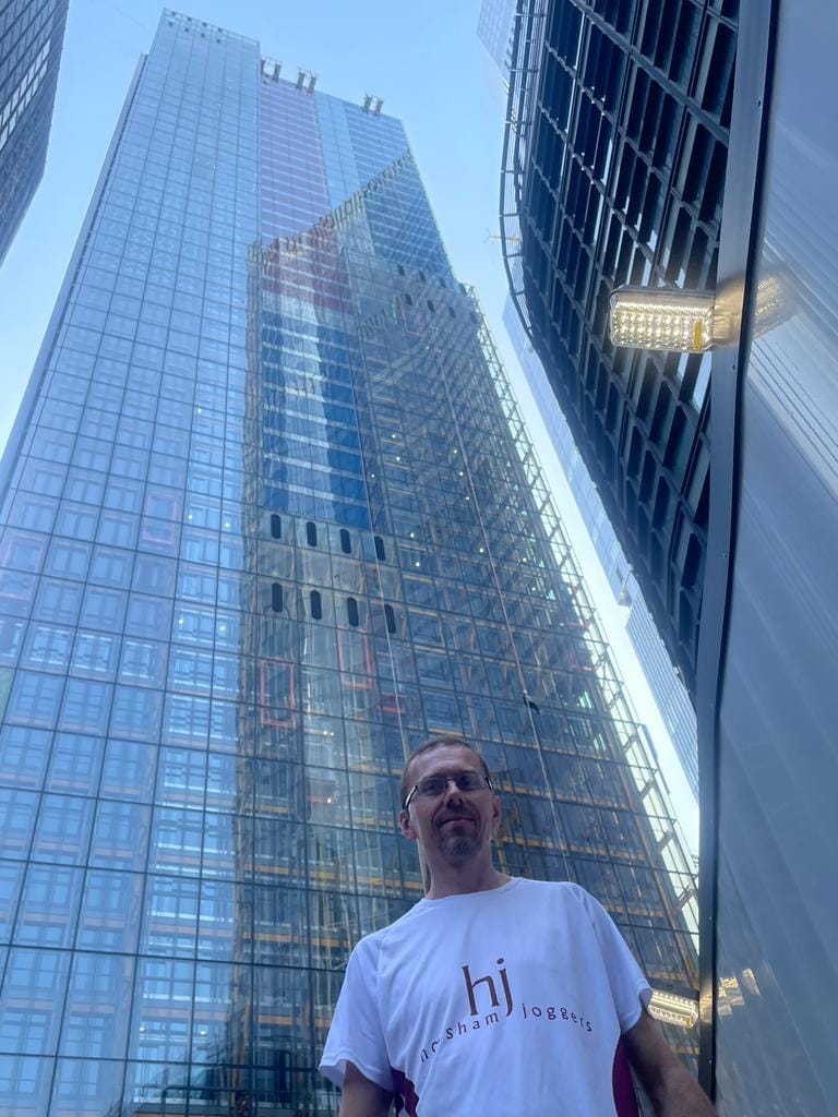 Lee Walker in front of the Cheesegrater skyscraper building
