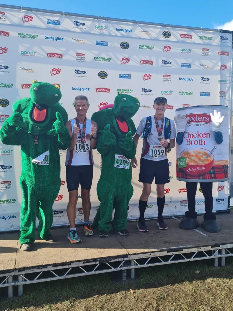 Two runners and three people dressed as Loch Ness monsters and a tin of soup