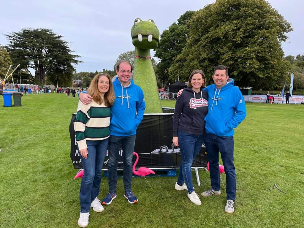 Four people in front of a Loch Ness monster mascot