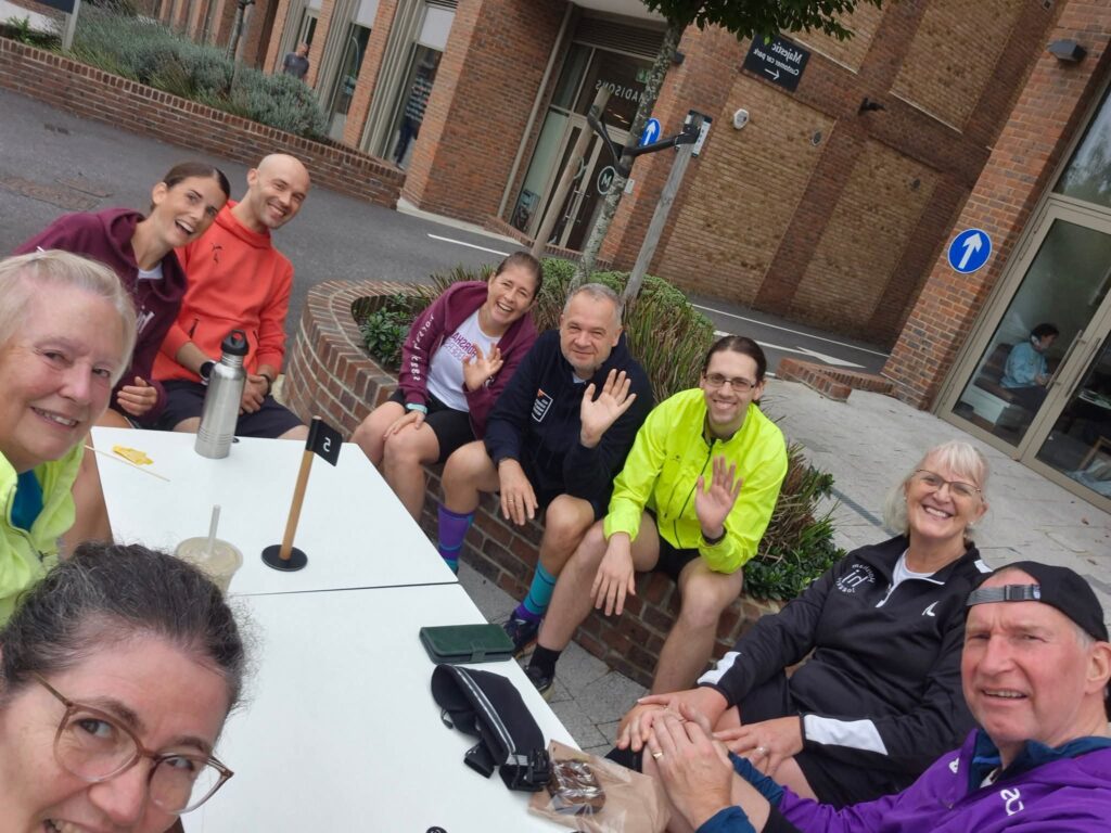 A group of Horsham Joggers sitting round a table.