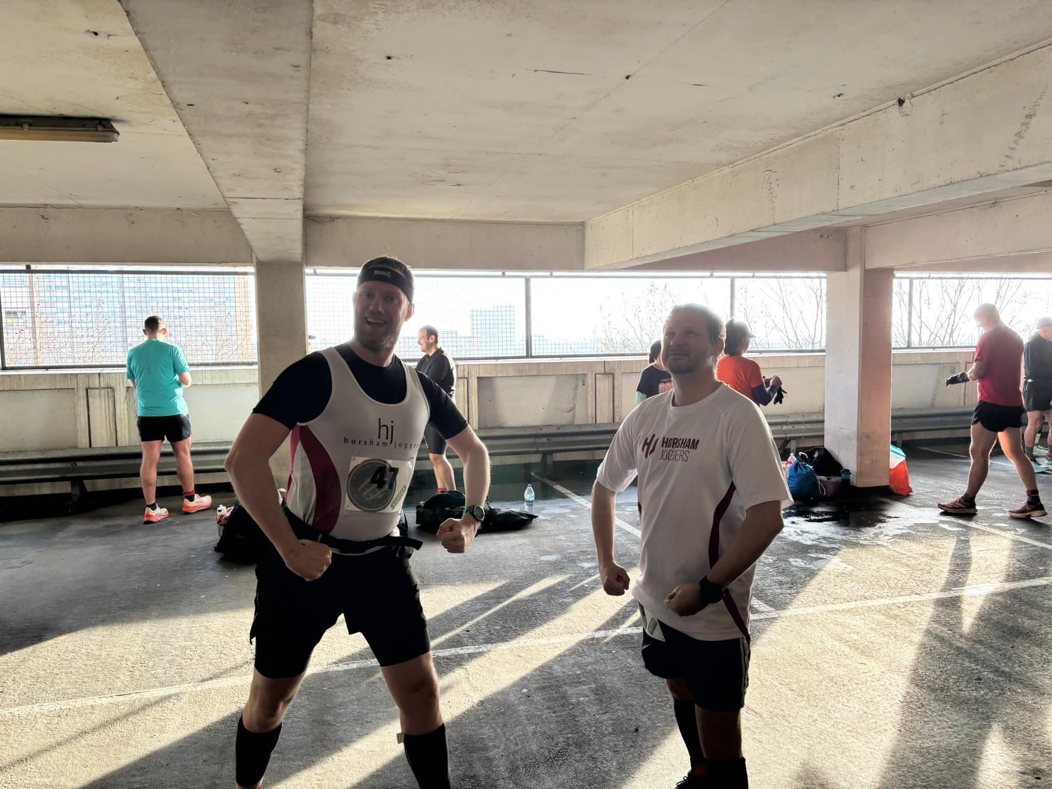 Two people in running kit in a multi-storey car park