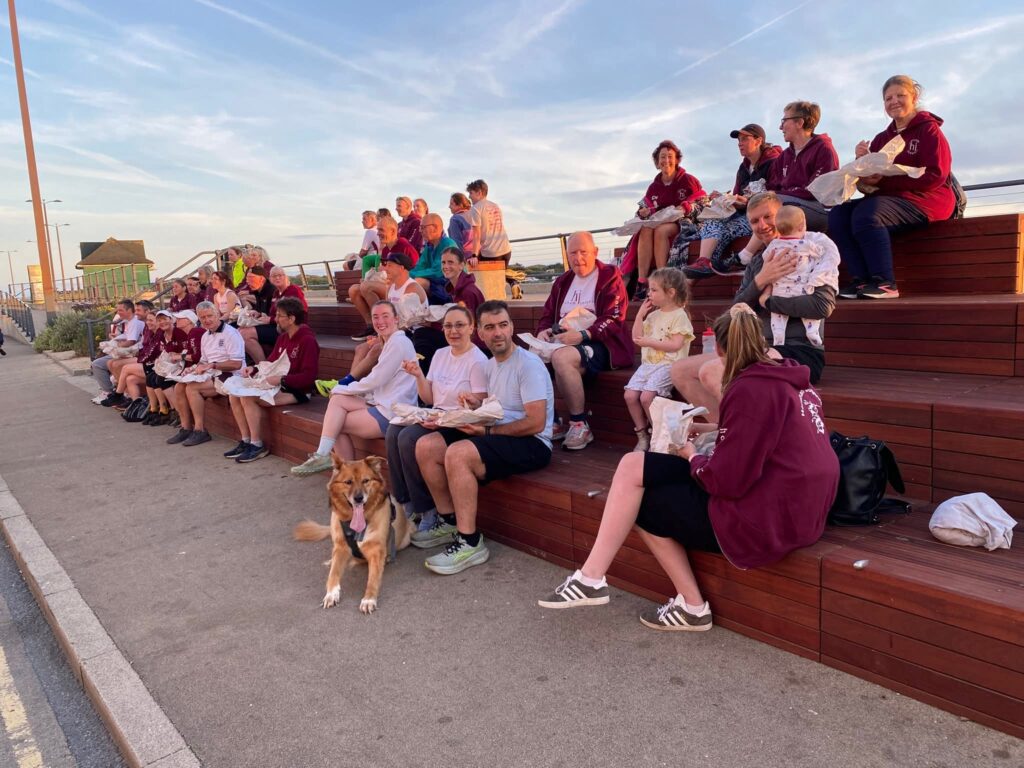 A large group of runners sitting on steps